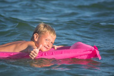Bir su üzerinde oynarken boy gülümseyerek