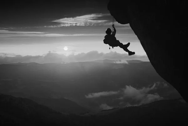 Escalador contra o pôr do sol. Preto e branco — Fotografia de Stock