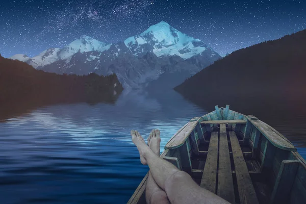 Человек отдыхает на альпийском озере ночью — стоковое фото