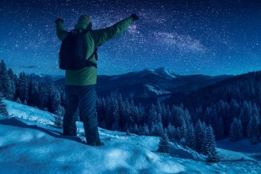 Yıldızlı gece gökyüzü karşı uzun yürüyüşe çıkan kimse