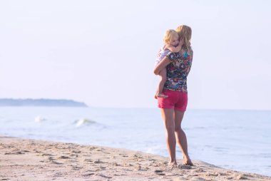 Anne kızını kucaklıyor.