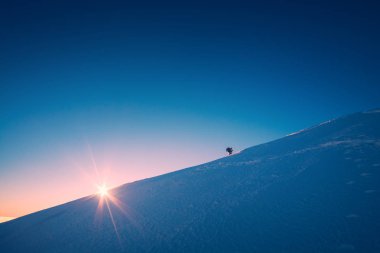 Bir tırmanıcı bir karlı yokuş tırmanıyor