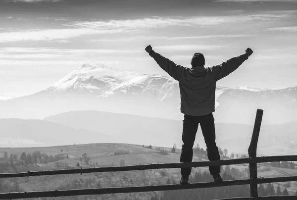 Un excursionista en una valla con la mano levantada. Blanco y negro —  Fotos de Stock