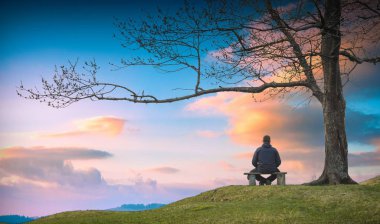 ahşap bir bankta oturan adam