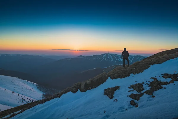 Турист стоит на холме и смотрит на горизонт — стоковое фото