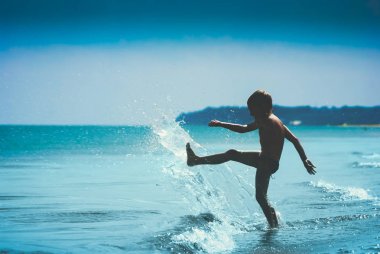 Childs siluet denizde oynuyor. Instagram biçimleşmeden