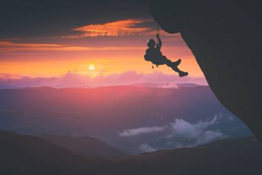 Dağcı günbatımı bir arka plana dayanır. Instagram biçimleşmeden