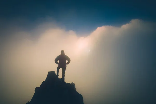 Hiker standing on a cliffs edge. Instagram stylization