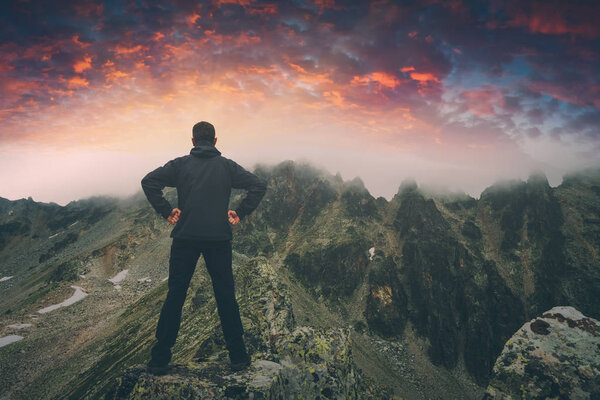 Hiker stays on a rocky ridge. Instagram stylization