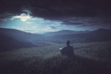 İnsan bir tepe üzerinde oturan ve aya düşüyor keyfini çıkarın. Instagram styl