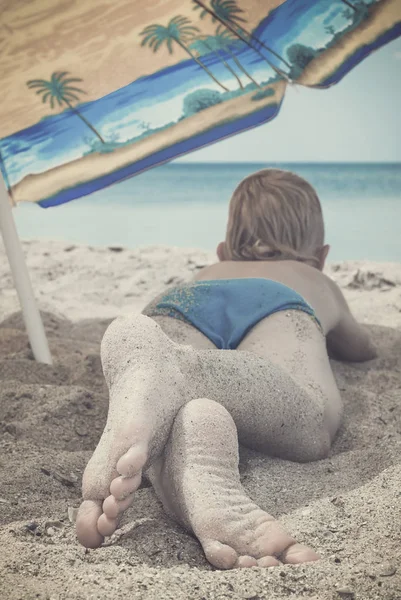 Jongen onder paraplu op een strand. Instagram stilering — Stockfoto