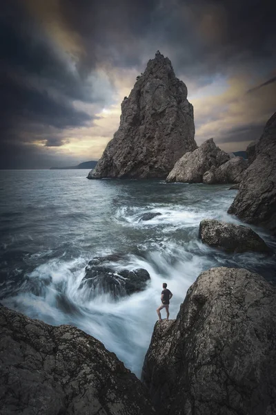 Homme sur un bord de falaise au-dessus de la mer. stylisation Instagram — Photo