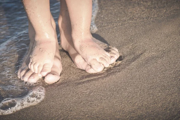 Mother and small baby play on a beach. Instagram stylization