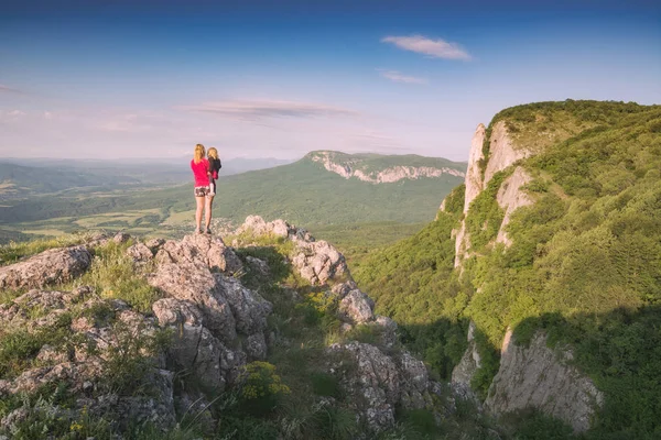 Kayalık üstte duran çocuk ile anne