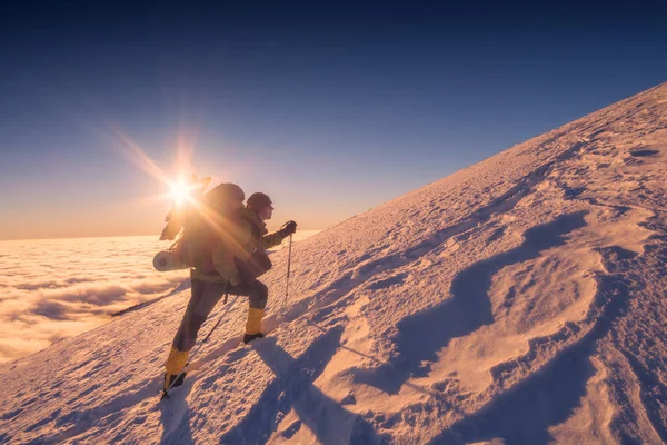 Un escalador con mochila y bastones de trekking — Foto de Stock