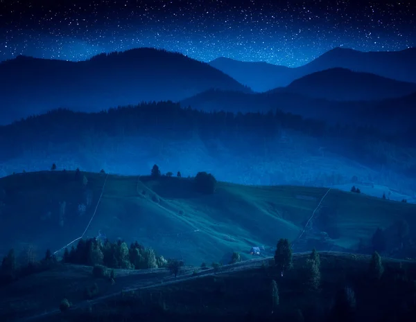 Karpaten dorp mistige heuvels in een maanlicht — Stockfoto