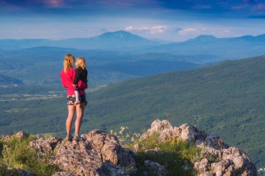 Kayalık kenarında duran bir çocuk ile anne