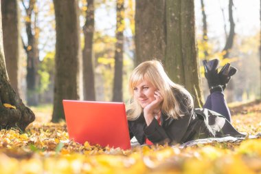 Not defterinde sonbahar bir park olan kadın