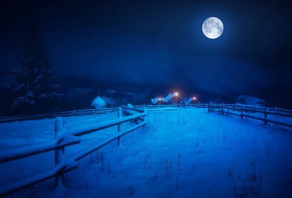 Vollmond über dem Dorf mit Neuschnee bedeckt — Stockfoto