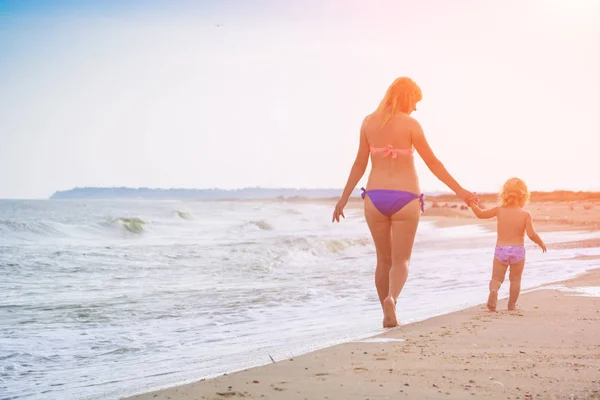 Madre con su pequeña hija caminando por la playa —  Fotos de Stock