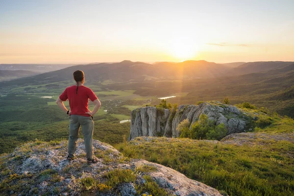 Emberi állva egy sziklás hegy, a naplemente fény — Stock Fotó