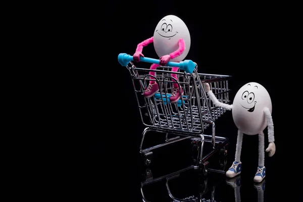 Twee grappige eieren met een kar uit een supermarkt — Stockfoto