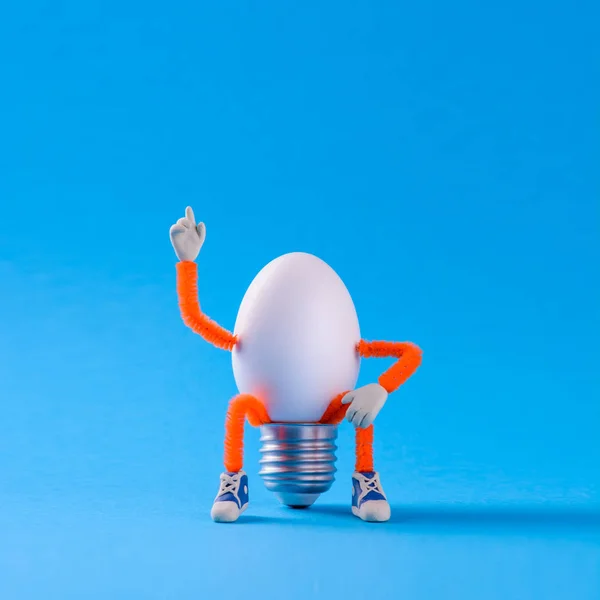 Easter egg toy in the shape of a light bulb on a blue — Stock Photo, Image