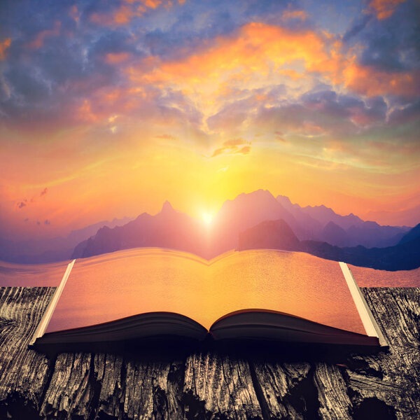 Colorful sunset above the sea on the pages of an open magical book. Majestic nature. Travel concept.