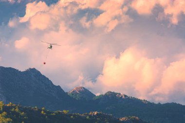 Helikopter dağlardaki yangını söndürdü
