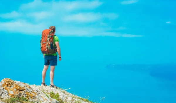 Man hiker with backpack on a mountain top — 스톡 사진