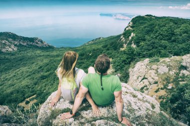 Uçurumdaki birkaç yürüyüşçü yukarıdaki dağ manzarasının tadını çıkarıyorlar. Seyahat konsepti. Klasik Biçimlendirme.