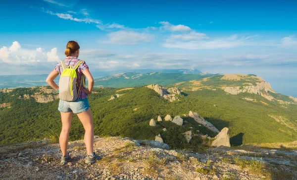 Młoda Dziewczyna Turysta Plecakiem Stoi Skalistym Wzgórzu Patrząc Dolinę Górską — Zdjęcie stockowe