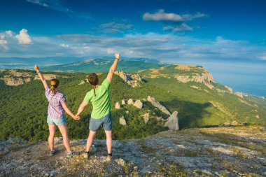Mutlu aktif çift yürüyüşçüleri Kırım Dağları manzarasının tadını çıkarıyor. Seyahat konsepti. Klasik Biçimlendirme.