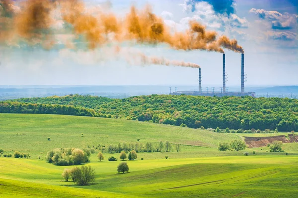 水平線上の発電所の煙管を持つ春のフィールド 生態学の概念 — ストック写真