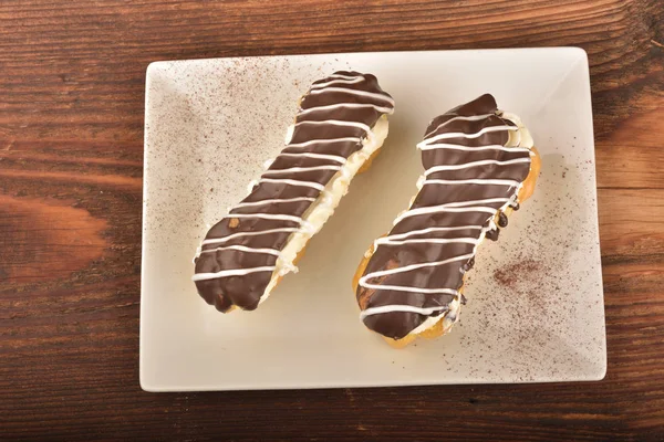 Eclair de chocolate saboroso e creme — Fotografia de Stock