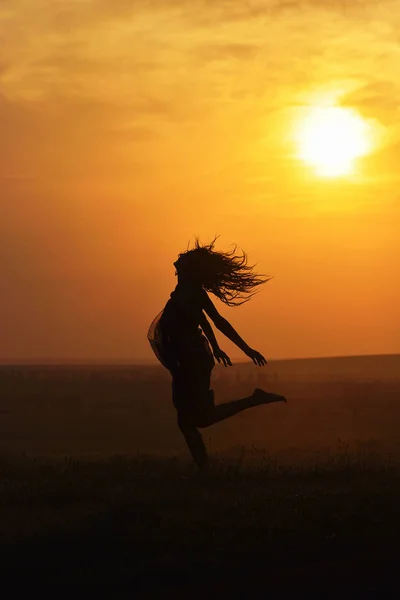 Silhouette di una bella ragazza al tramonto — Foto Stock