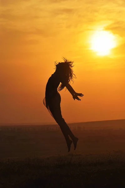 Silhouette di una bella ragazza al tramonto — Foto Stock