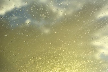 bir araç penceresinin üstünde su damlaları