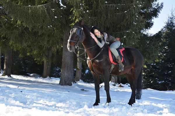 冬の屋外の馬に乗って若い女性 — ストック写真