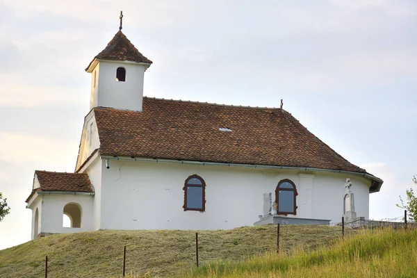Pequeña iglesia en la cima de una colina verde —  Fotos de Stock