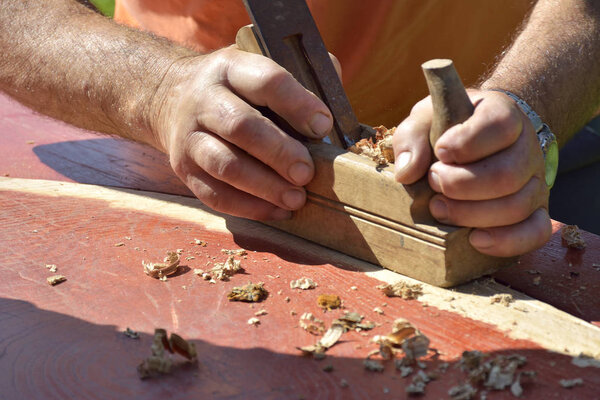 Wooden planer, table from old wood, a natural building material, handcrafted wood, ancient hand tools, carrying out carpentry, joinery tools, wood sawdust, old wood texture