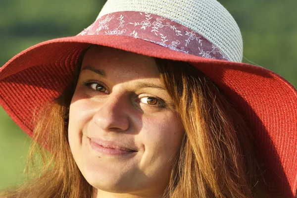 Beautiful happy woman in hat on summer meadow
