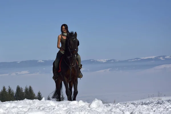 young woman riding horse outdoor in winter