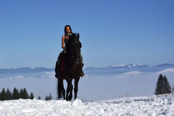 young woman riding horse outdoor in winter