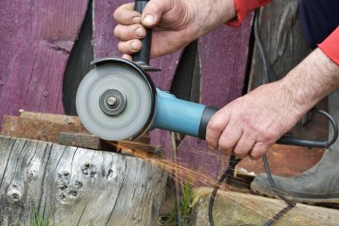 Elektrik değirmeni. Elektrik değirmeni aracıyla fabrikasında, çelik yapı üzerinde çalışan bir erkeğin kıvılcım uçan