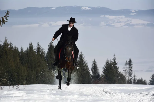 Молодий чоловік верхи на коні взимку — стокове фото