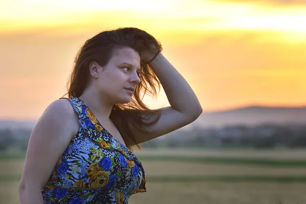 Lycka kvinnan vistelse utomhus i solljus av solnedgången — Stockfoto