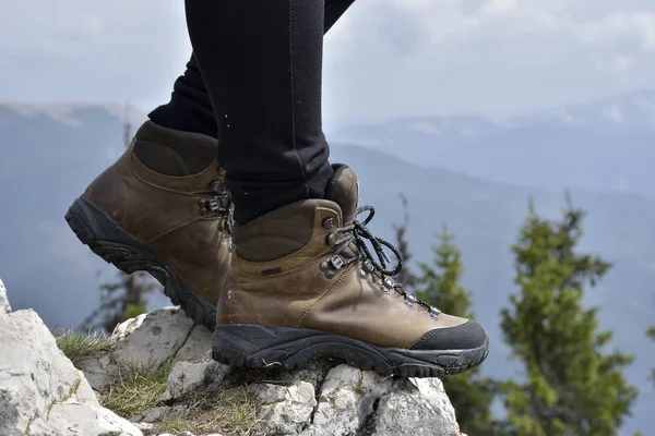 Turistické boty na skále, v horách. žena turista stojí na skalách vrcholu — Stock fotografie