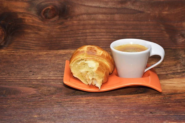 Šálek kávy s croissantem izolované na dřevěný stůl — Stock fotografie