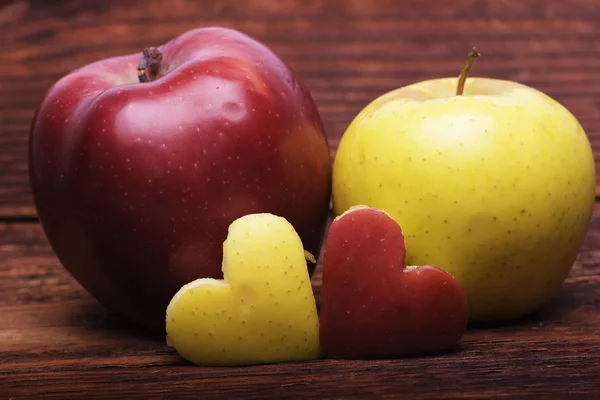 Two apples with heart on wood